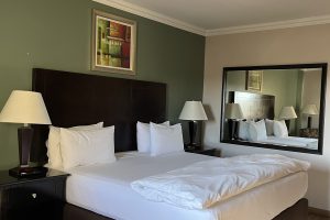 Hampshire hotel King bed with white linen sheets and cover with pedestals and lights